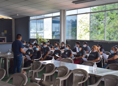 Capacitacion de personal con un instructor frente a un grupo de trabajadores.